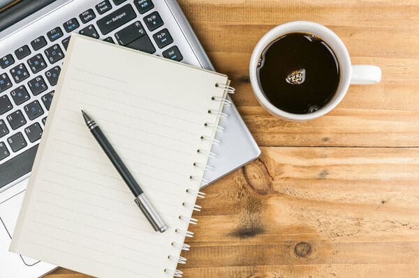 Persona con libreta y café revisando notas